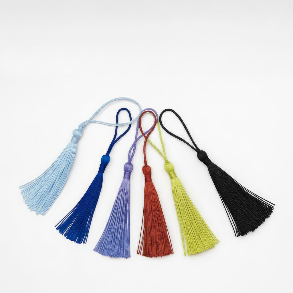 Assorted tassel colour options for personalised children’s metal bookmarks – light blue, royal blue, lilac, red, lime green and black tassels displayed on white background.