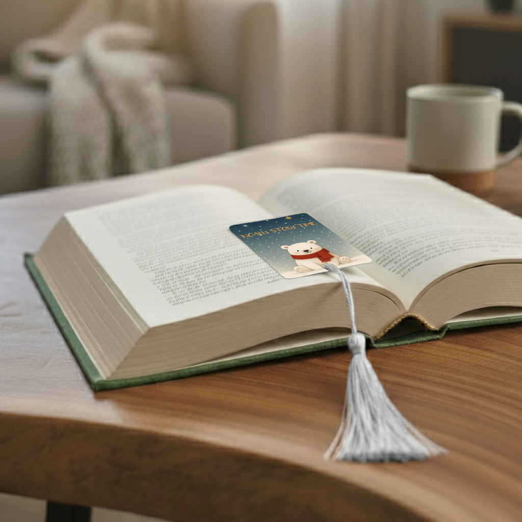 Lifestyle photo showing personalised polar bear metal bookmark placed in an open book with white tassel – high-quality children’s bookmark reading gift handcrafted in the UK.