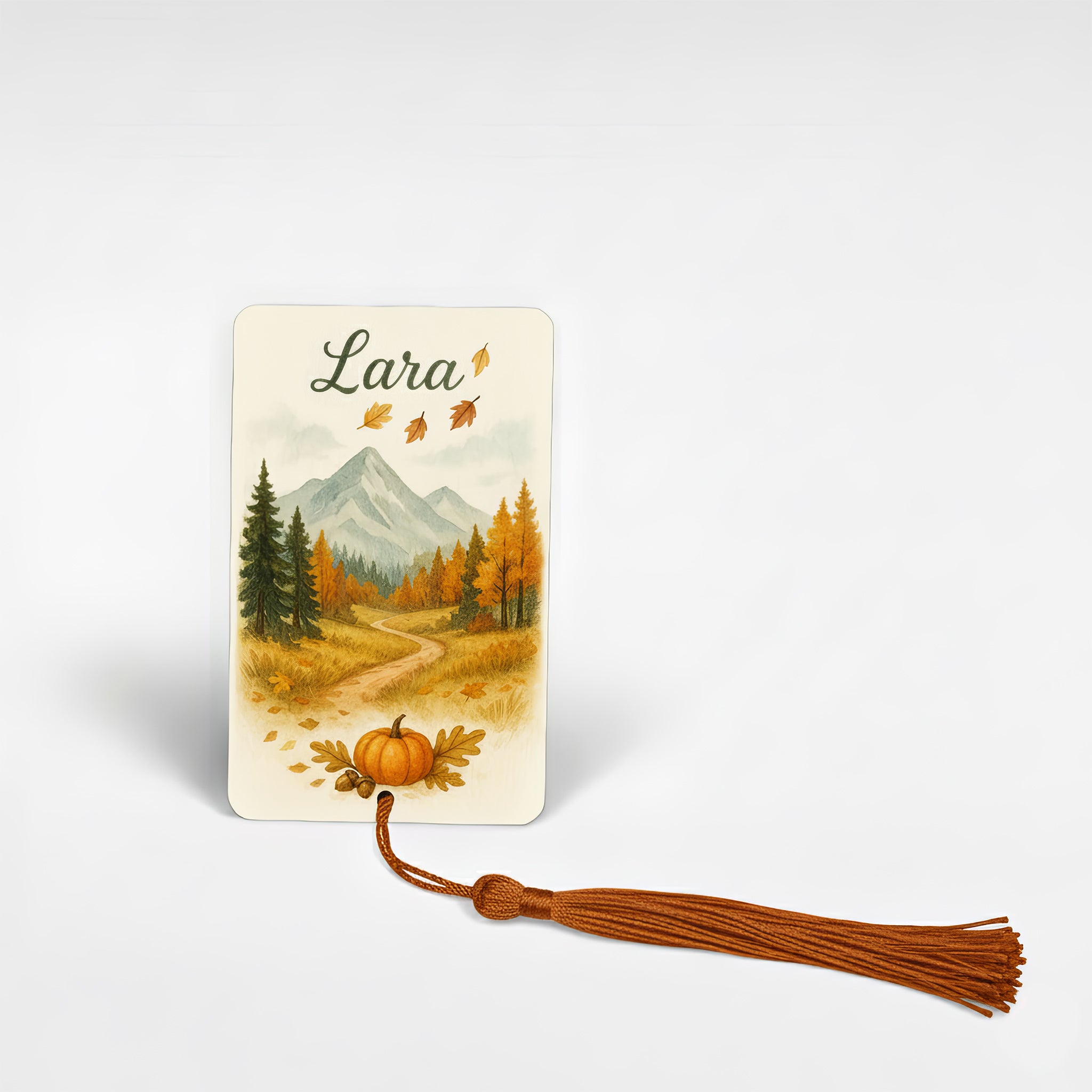 Personalised metal bookmark featuring autumn mountain landscape design with falling leaves and pumpkin illustration, handcrafted in the UK — cosy autumn reading gift for book lovers.
