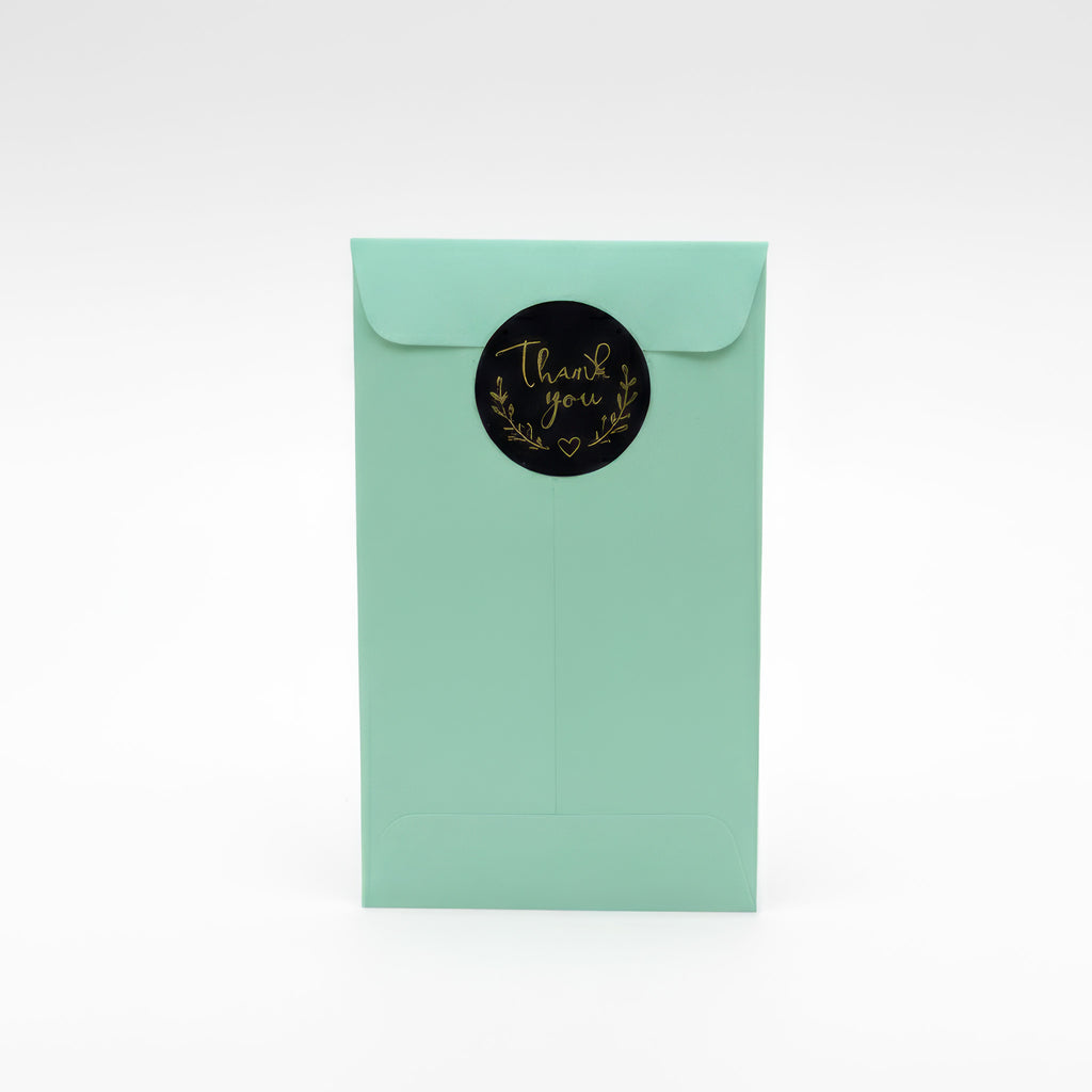 Gift packaging for personalised dachshund fridge magnet – mint green envelope with gold “thank you” sticker, ready to send as thoughtful sausage dog gift for dachshund owners.