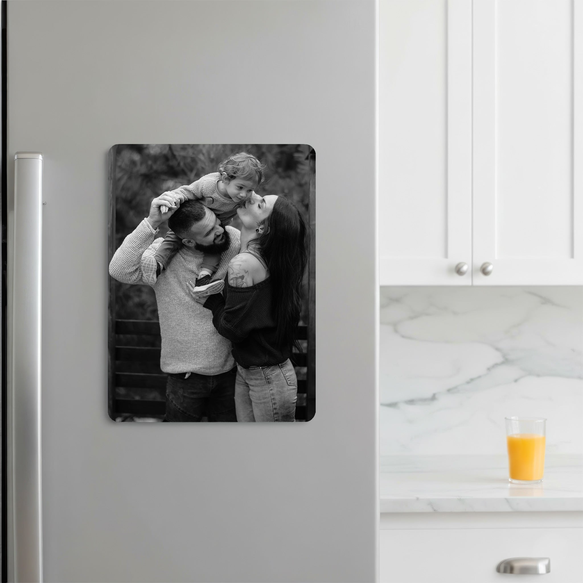 Monochrome personalised family photo fridge magnet printed on glossy aluminium, displayed on a modern grey fridge.