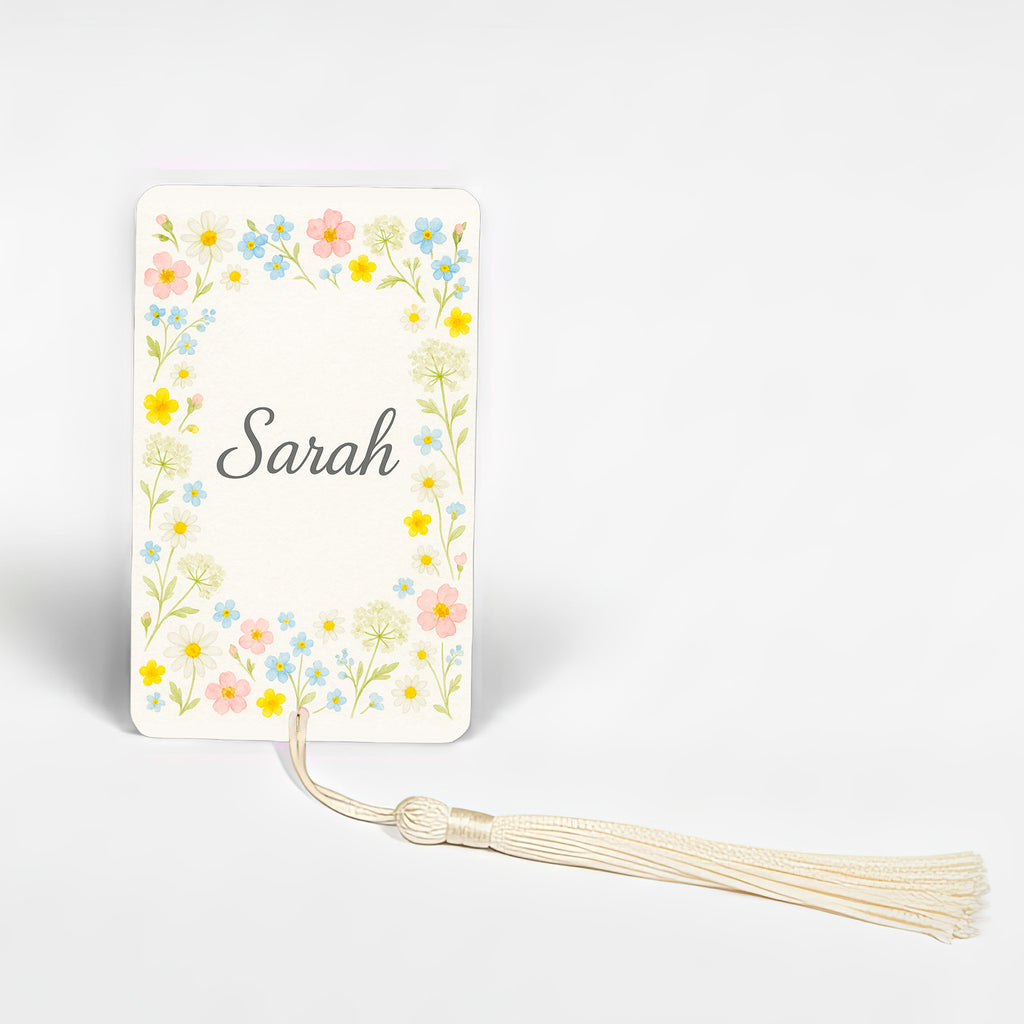 Personalised wildflower meadow bookmark with name Sarah, cheerful mix of yellow, pink, and blue blooms in watercolour style, handmade metal bookmark made in England.