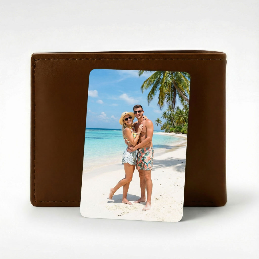 Custom photo wallet card printed with a couple's beach photo, shown resting against a standard men's brown leather wallet.